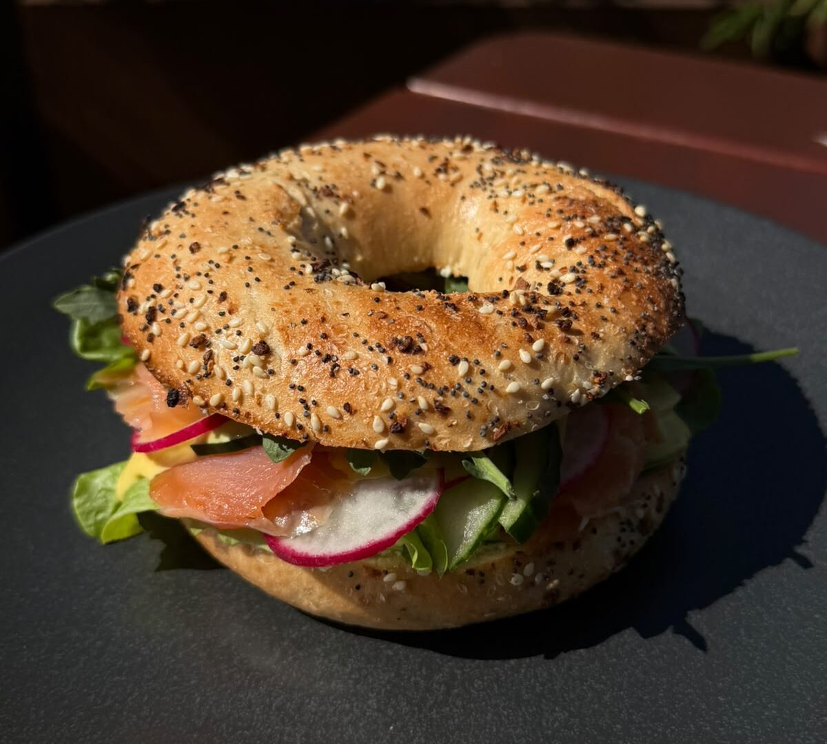 East Side Bagel mit Cream Cheese, Räucherlachs, Honig-Senf-Sauce, Rucola